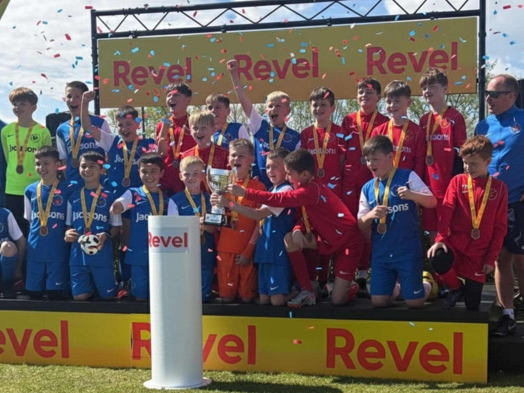 A squad on the Revel podium with their medals and the cup