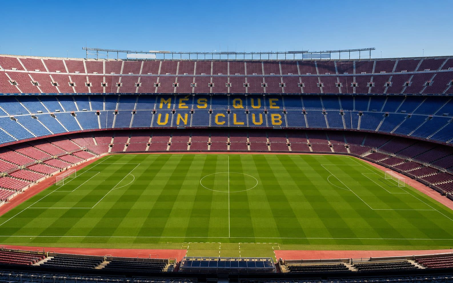 The empty bowl of Camp Nou seen from the stand, Mes Que Un Club picked out in the seats